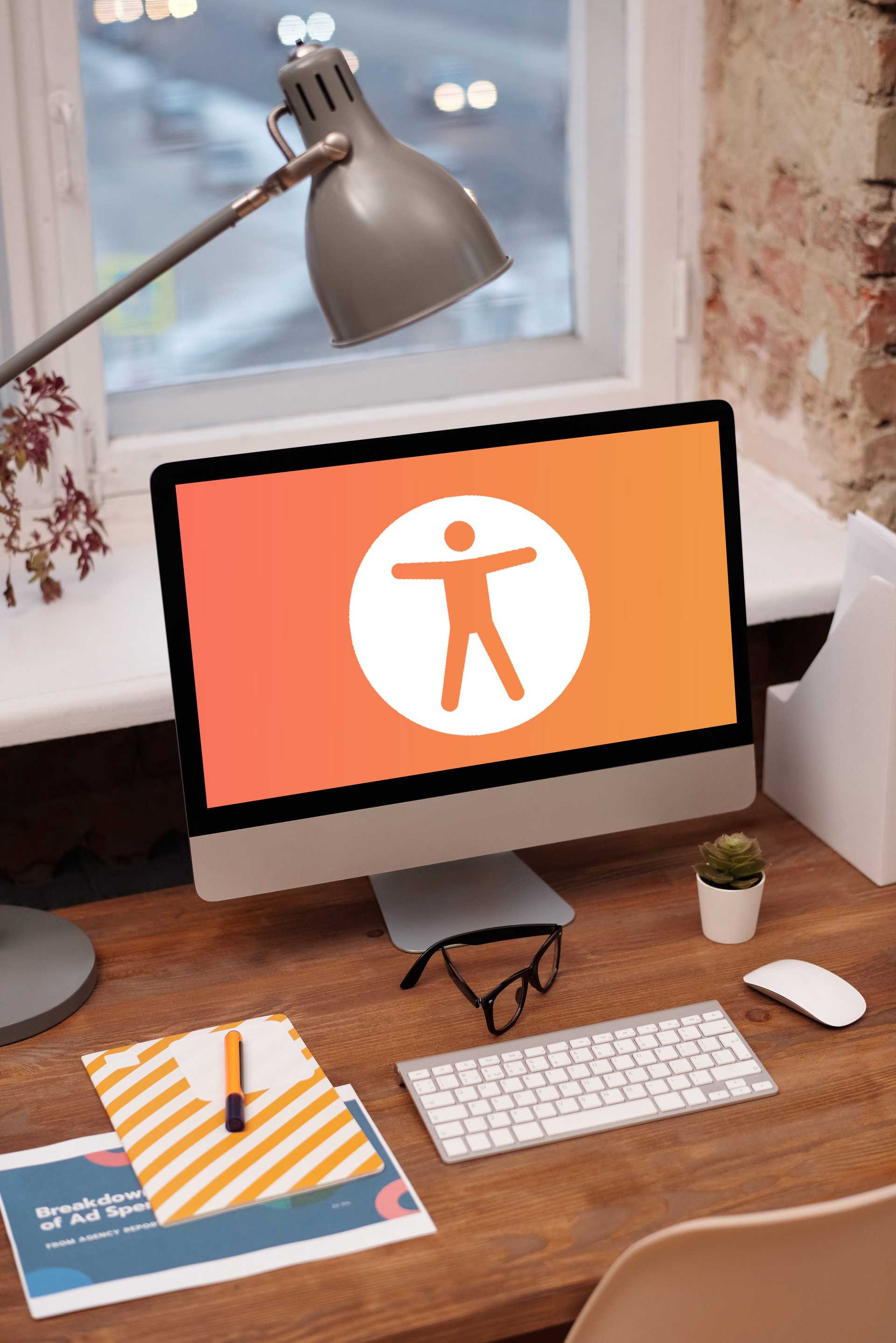 Computer monitor on desk showing orange and white human stick figure