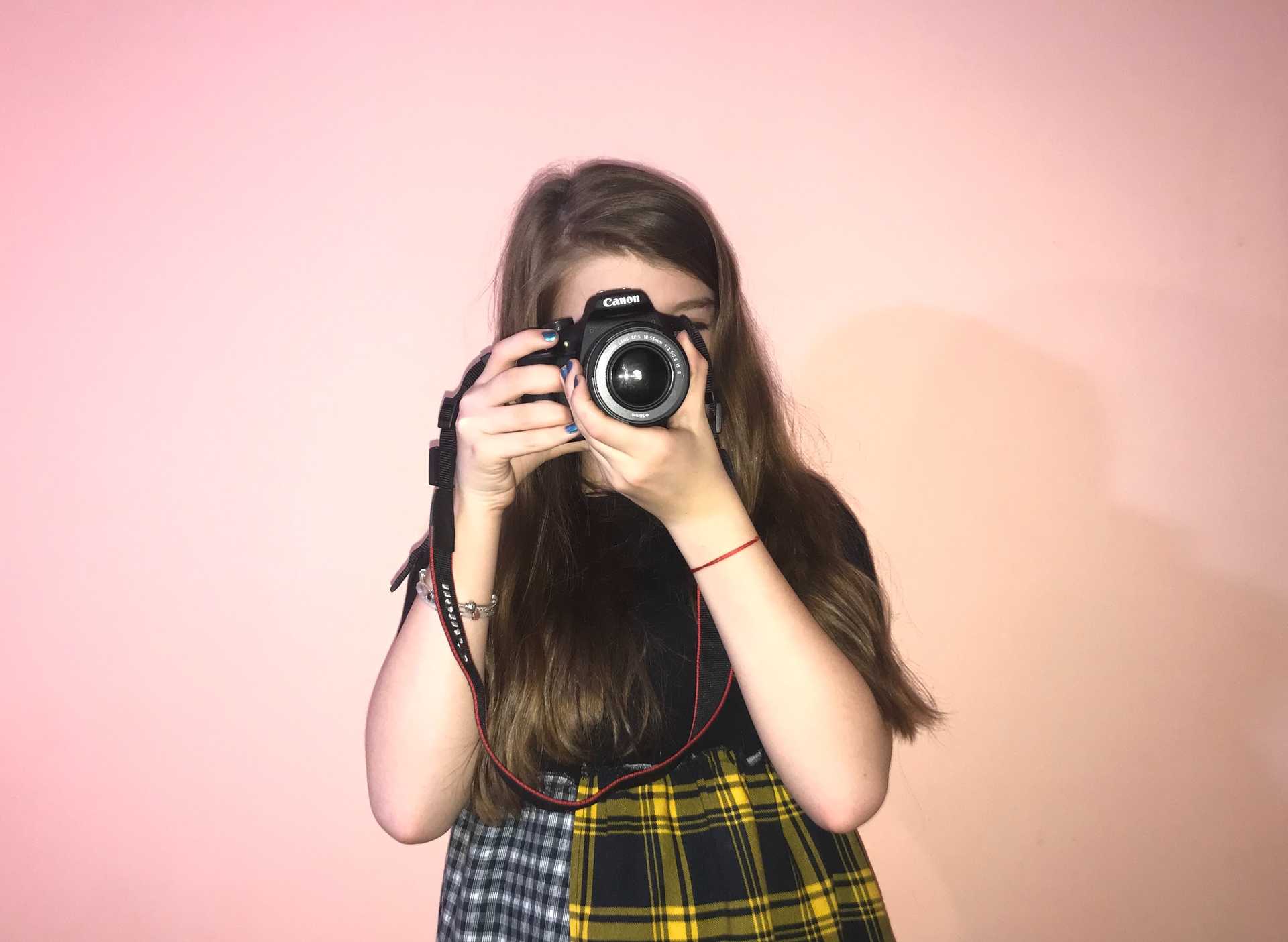 girl holding camera in front of her face