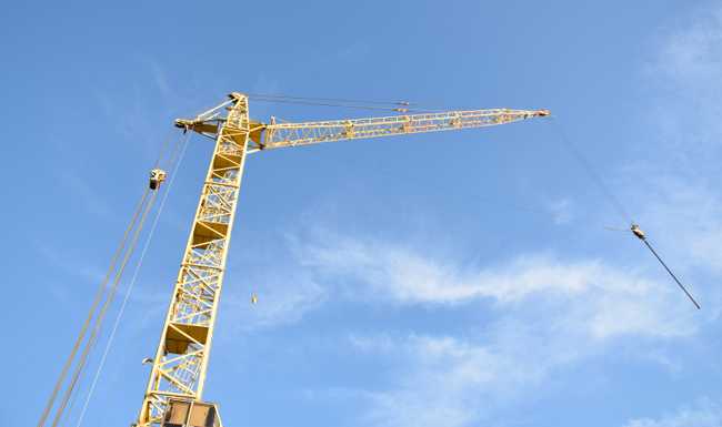 yellow building crane against blue sky