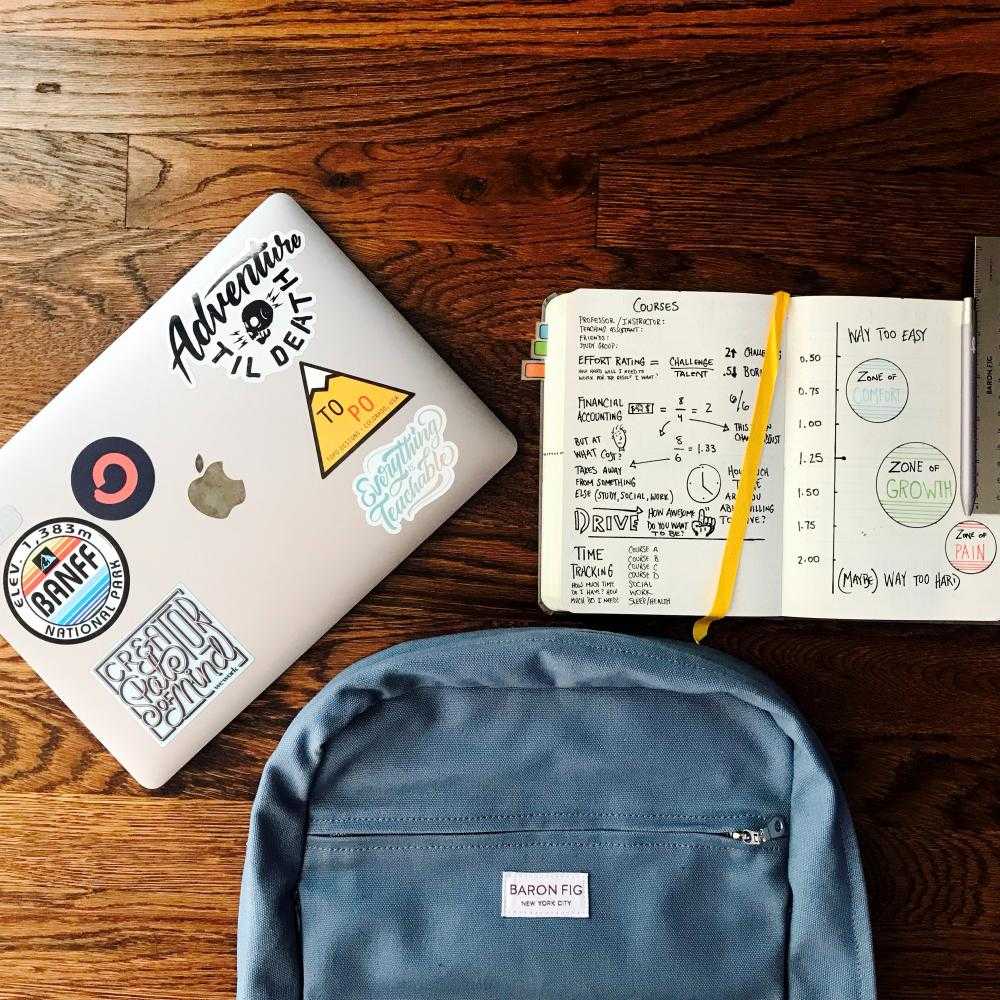 A laptop, a journal and a backpack
